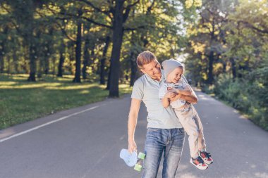 Mutlu baba ve oğul parkta bir kaykay ile