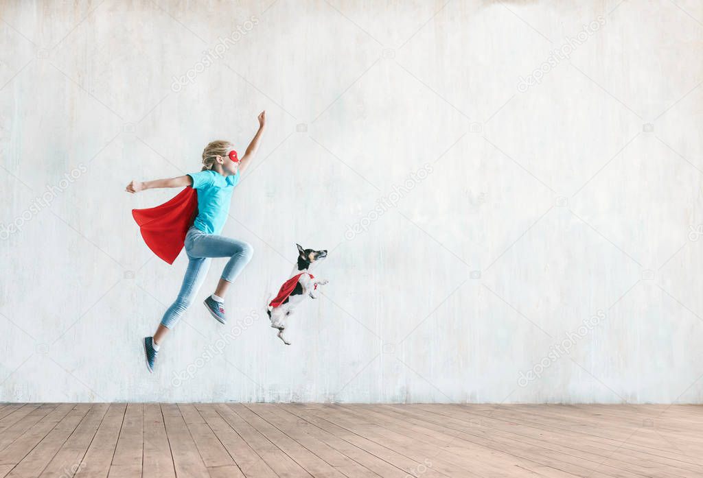 Jumping little child with a dog indoors