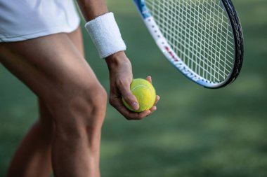 Tennis player in sportswear with a ball close-up clipart