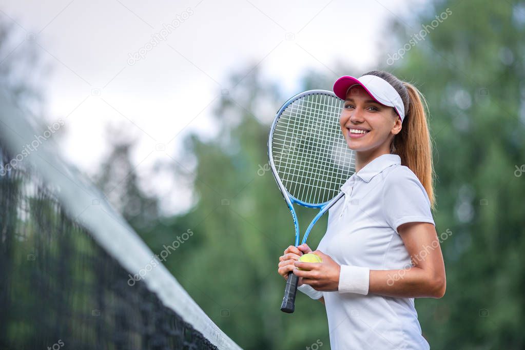 Happy woman with a tennis racket outdoors