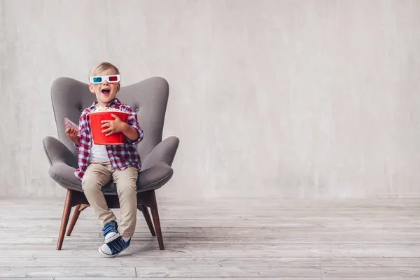 Surprised boy in 3d glasses with popcorn in cinema