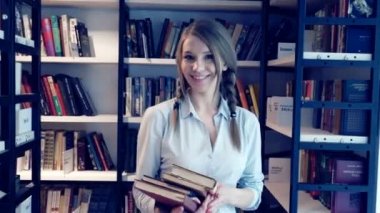 Kitaplığındaki kitap ile genç öğrenci