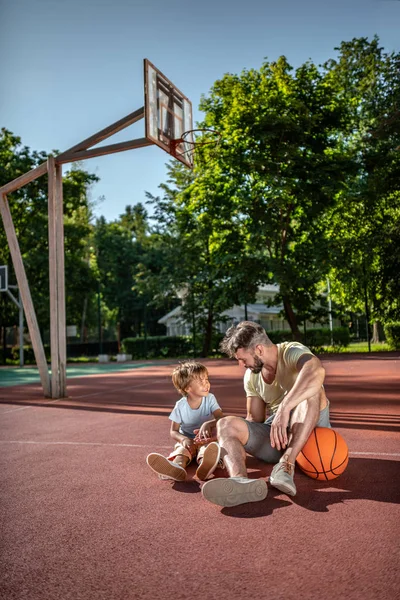 Father and son on the basketball court near the house