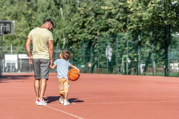 Father and son on the basketball court in summer