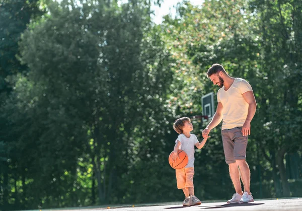 Father and son on the basketball court outdoors