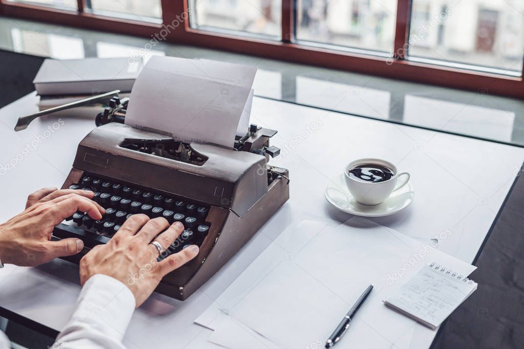 Men's hands typing on a retro typewriter close-up