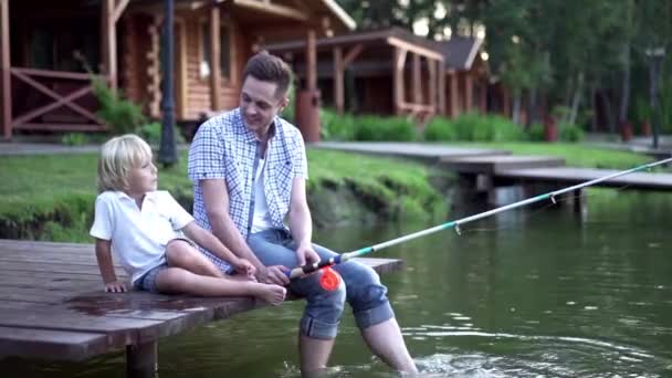 爸爸和儿子在码头钓鱼 — 图库视频影像