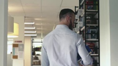 genç adam bir kitaplığı