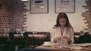 Çekici kız bir kafede fotoğraflarla