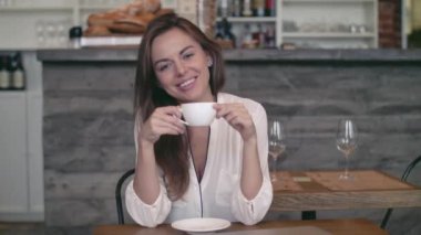 Bir fincan kahveyle gülümseyen kadın