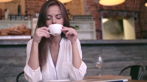 若い女の子のカフェでコーヒーを飲む — ストック動画