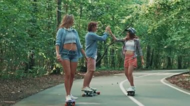 Parkta kaykaylar üzerinde mutlu gençlik