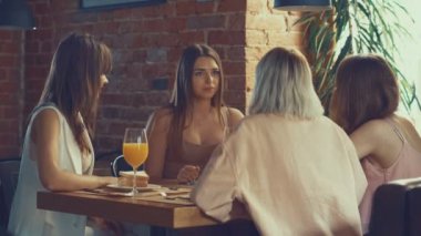 Genç kızlar bir kafede konuşuyor