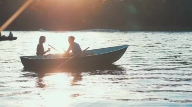 Günbatımında bir tekne içinde çift öpüşme
