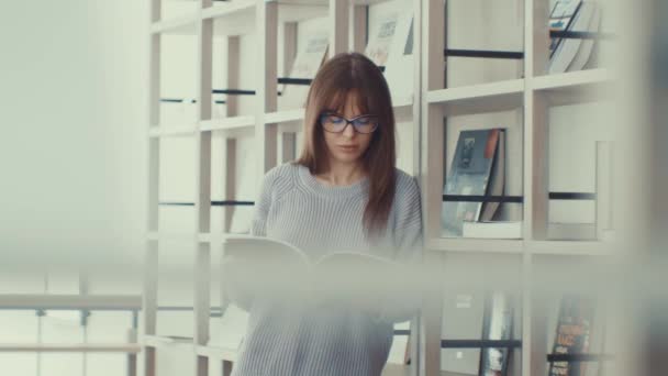 Chica Atractiva Leyendo Libro Biblioteca — Vídeo de stock