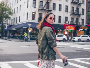 New York'ta retro bir fotoğraf makinesi ile güzel kız