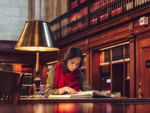 Νεαρή Κοπέλα Που Διαβάζει Ένα Βιβλίο Στη Βιβλιοθήκη — Φωτογραφία Αρχείου