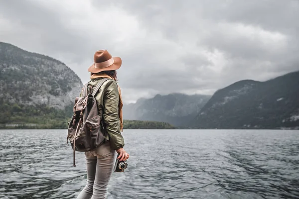 Jonge fotograaf in een hoed aan het meer — Stockfoto