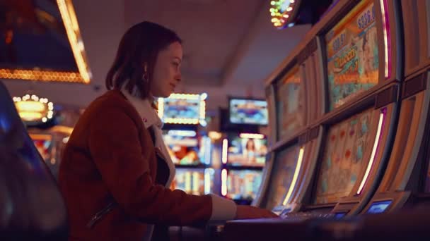 Chica joven jugando con una máquina tragaperras — Vídeos de Stock