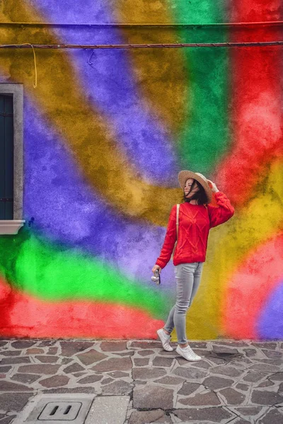 Усміхнена дівчина на фоні кольорової стіни — стокове фото