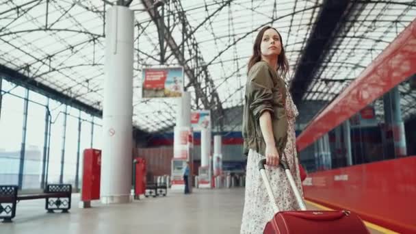 Attraktives Mädchen mit Gepäck am Bahnhof — Stockvideo