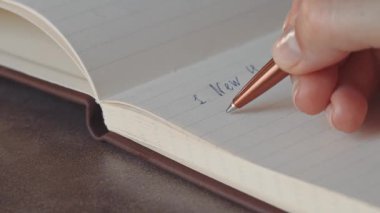 Genç kız bir not defterinde şehirler yazma