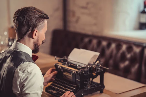 Giovane uomo che scrive su una macchina da scrivere retrò — Foto Stock