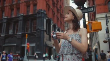New York'ta bir retro kamera ile genç kız gülümseyerek