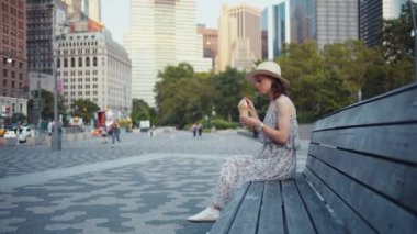 Şehirde bir bankta dondurma yiyen genç kız