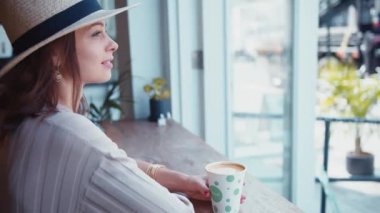 Kafede bir fincan kahve içen çekici bir kadın.