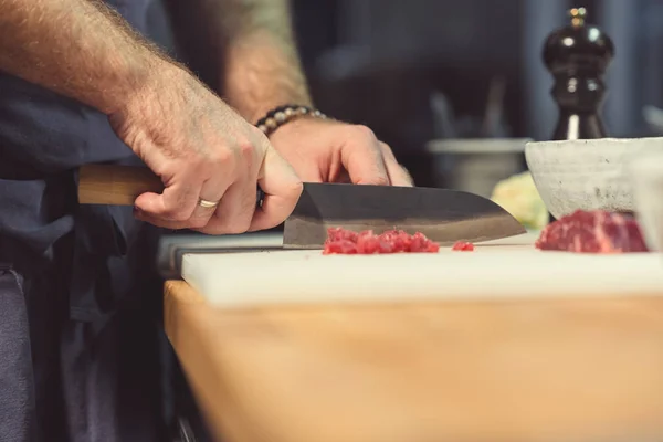 Chef profesional cortando carne en la cocina — Foto de Stock