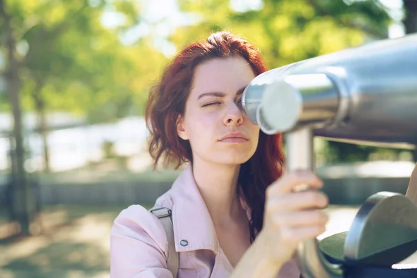 Chica joven mirando a través de un telescopio al aire libre —  Fotos de Stock