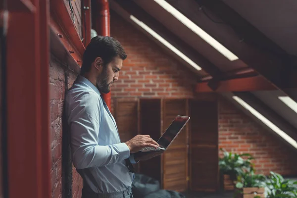 Joven hombre de negocios con un portátil —  Fotos de Stock