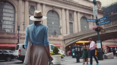 Grand Central Terminali 'nde elinde retro kamera olan genç bir kadın. 