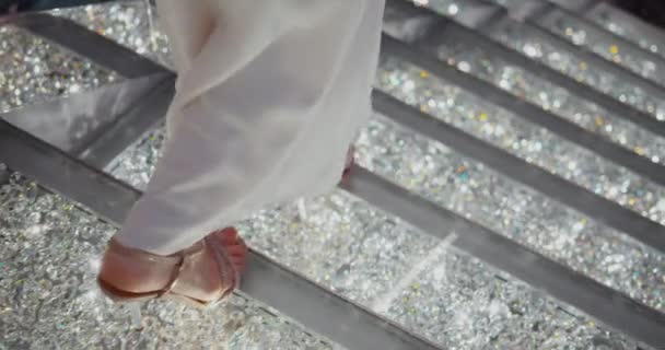 輝く階段の上でドレスを着た若い女性 ブラックマジックシネマカメラで撮影 — ストック動画