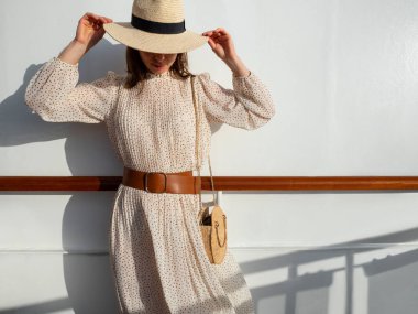 Güneşin altındaki duvarda çekici bir kız.