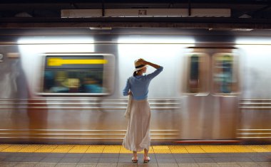 Metroda tren bekleyen çekici bir kız.