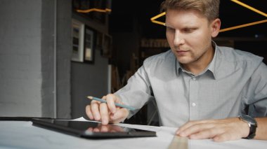 Ofisinde tableti olan genç bir mimar.