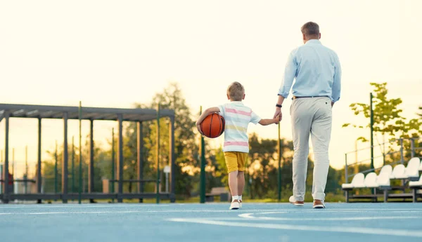 Father and son leaving the basketball court