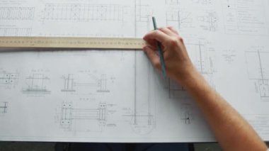 Mühendis elleri bir inşaat planı çiziyor.