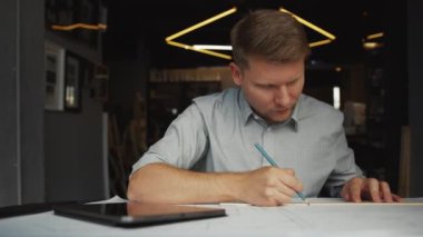 Ofiste tableti olan genç bir mühendis var.