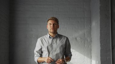 Genç tasarımcı ofisteki boş alana bakıyor.