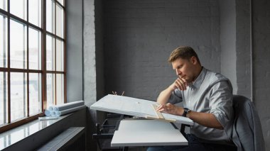 Ofisteki pencerede çalışan tasarımcı