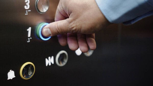 Male hand pressing the elevator button close-up