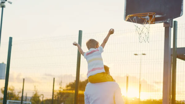 Mann Und Kind Bei Sonnenuntergang Auf Dem Basketballplatz — Stockfoto