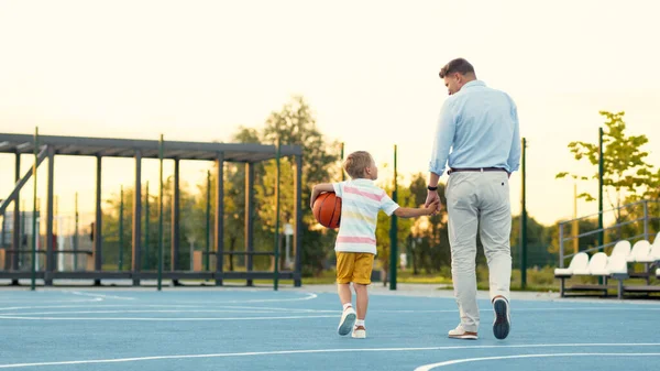 Father and son on the basketball court in summer