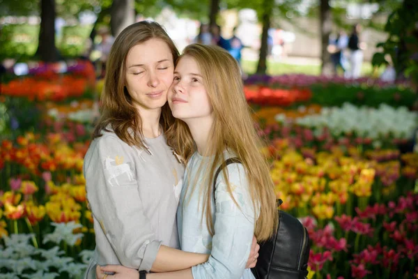 Счастливые Улыбающиеся Мама Дочь Подросток Обнимаются Парке Фоне Луга Тюльпанов — стоковое фото