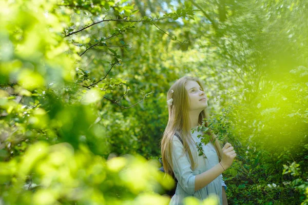 年轻美丽的少女摆在公园里的绿叶间 — 图库照片#