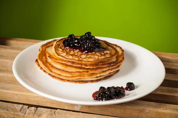 Pancakes with jam on green — Stock Photo, Image
