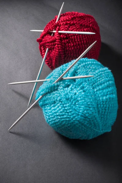 Ball of wool and knitting needles on dark — Stock Photo, Image